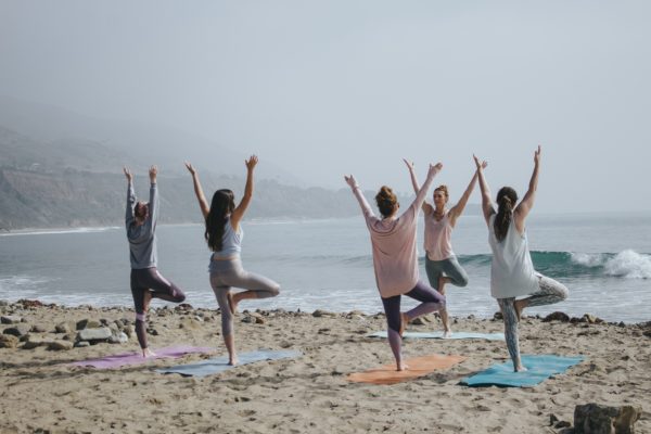 stock image group of women on beach doing yoga